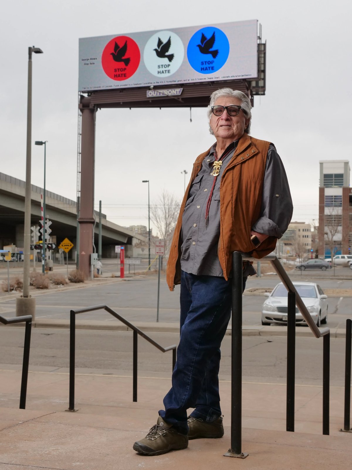 George Rivera, Ph.D., standing in front of his Stop Hate billboard, Denver